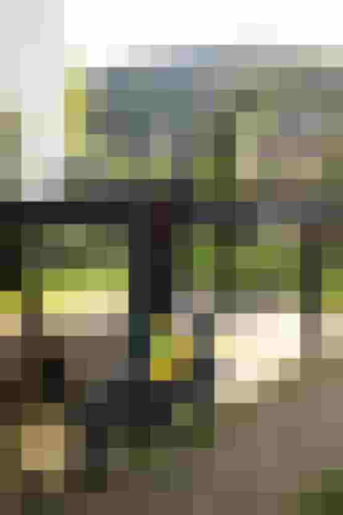 Tischtennisplatte im Freien mit Schlägern, umgeben von Alpenlandschaft und grüner Natur.