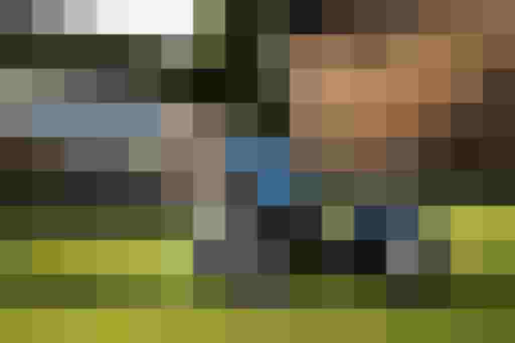 Kind spielt mit einem blauen Spielzeugtraktor auf dem Bauernhof in Saalfelden.